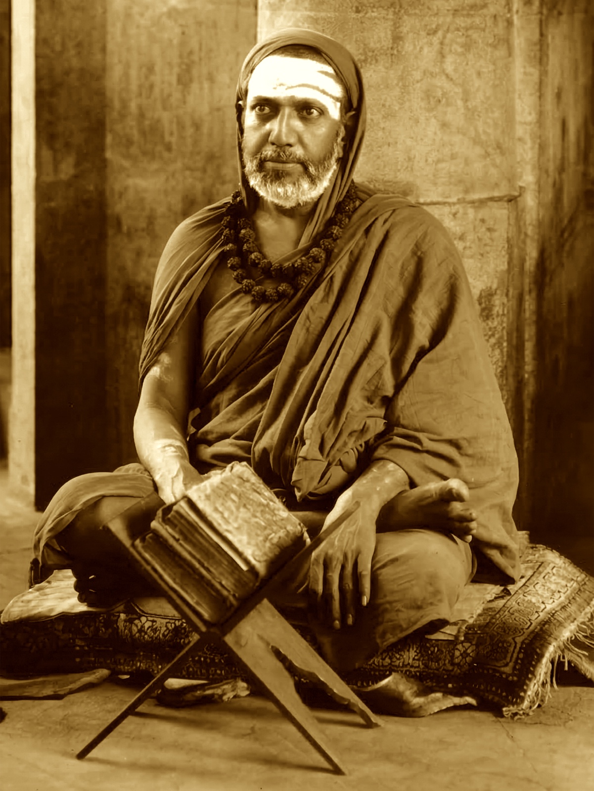 The Jagadguru seated, a volume open on a stand before him